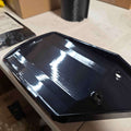 Factory Drain Tray for F-150 & Expedition 20152025 showing glossy black design and pre-drilled holes for installation.